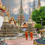 Two monks walking alongside stupas at the Wat Pho Temple in Bangkok