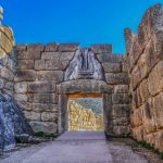 Bright Greek sunlight shines of rock wall of ancient Mycenae on the road up to the famous Lions Gate into the hill fortress where the armies of Troy originated